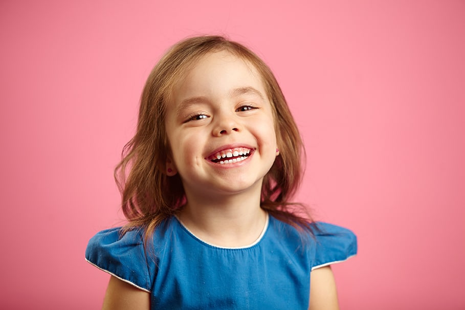 girl smiling  in Denver CO with pink background